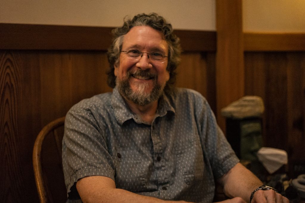 Rob Guise sitting in a chair in his office smiliing